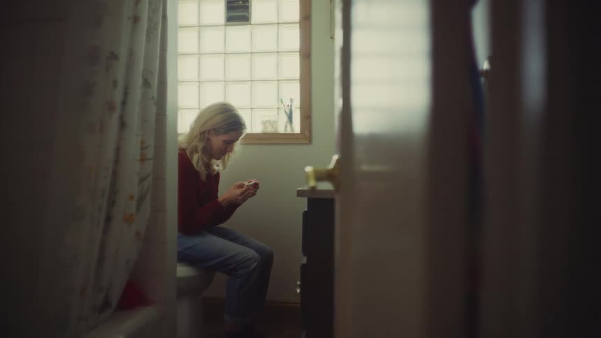 The woman reads a pregnancy test and smiles