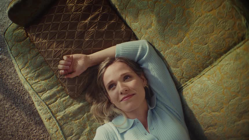 Woman smiling while resting on a couch