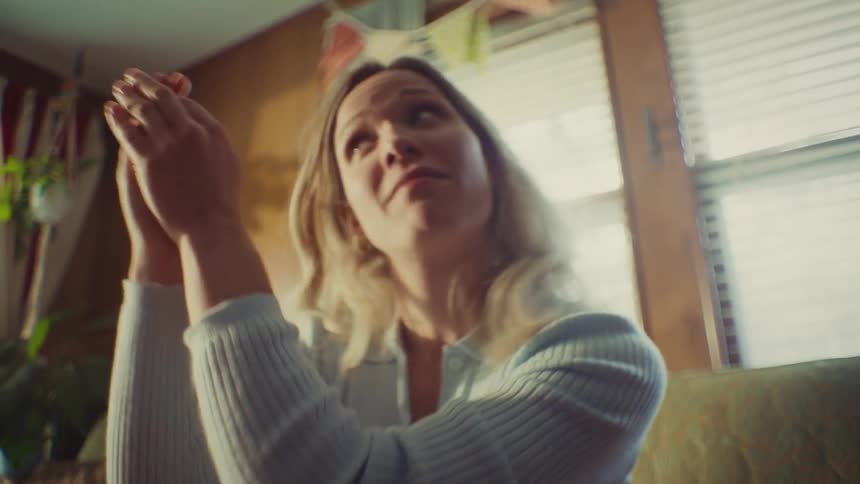 The video quickly cuts between a man in a white tshirt and a blonde woman both appearing energized and speaking or singing with great enthusiasm the woman is shown clapping and then making an excited surprised face while leaning forward
