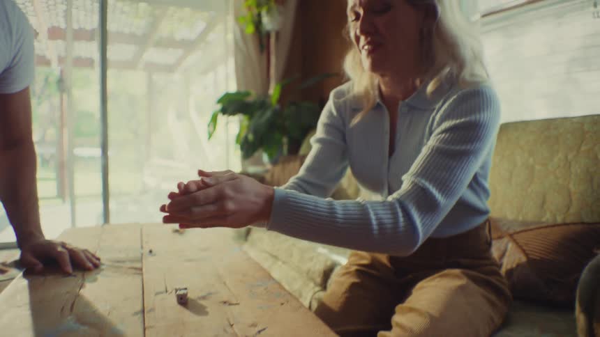 The woman rolls dice and begins shouting