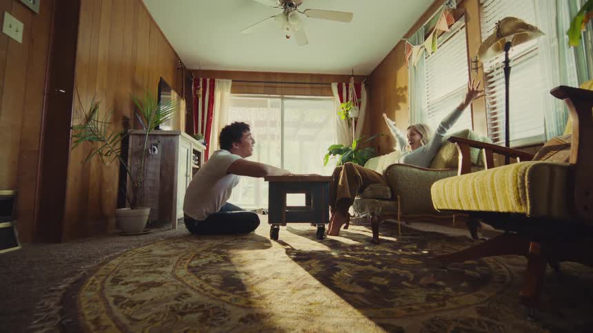 The man and woman laugh and wave their arms