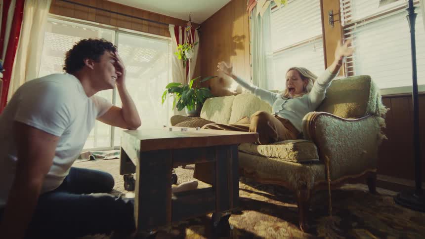 The woman jumps up laughing as she talks with a man