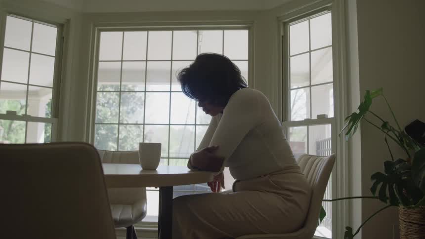 The woman having coffee at home looks depressed