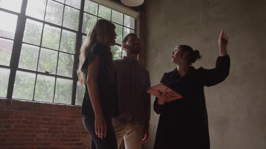 Real estate agent showing potential home buyers property
