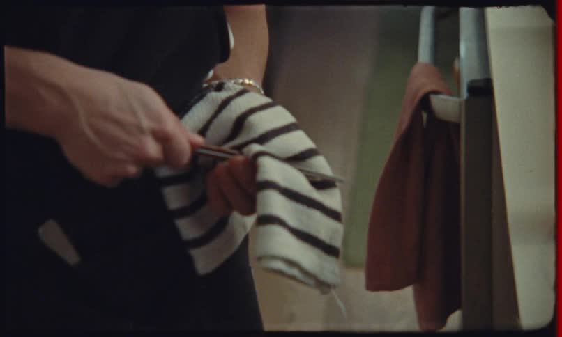 Person cleaning a kitchen utensil with a striped cloth