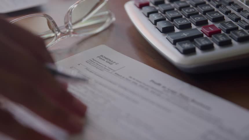 A person flips through paperwork on the desk