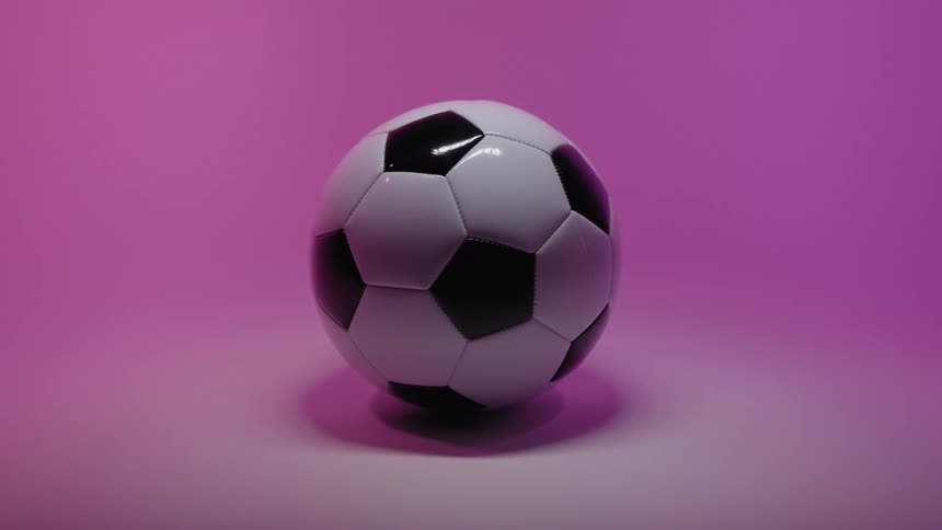 Black and white soccer ball lit by soft purple light