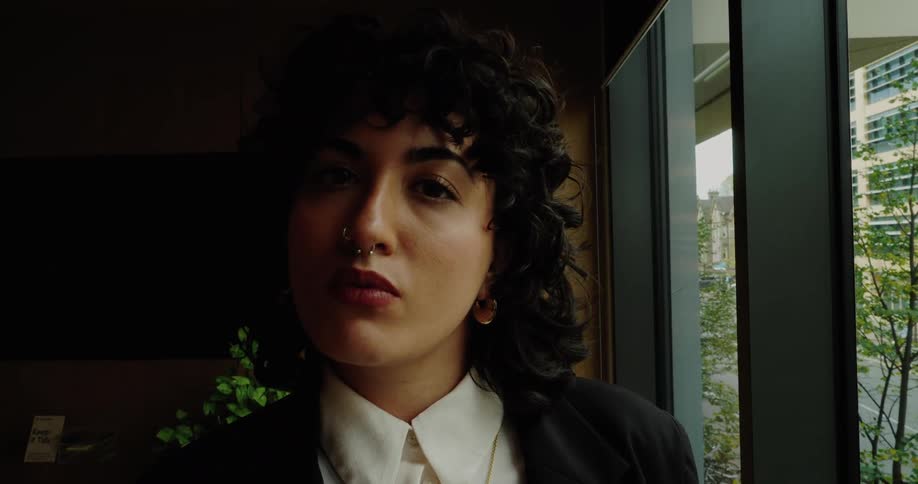 A confident business woman stands in a modern conference room in an office