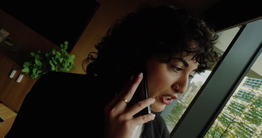 A woman talking on a phone in a room