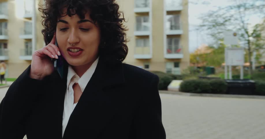 A woman talking on a phone outdoors