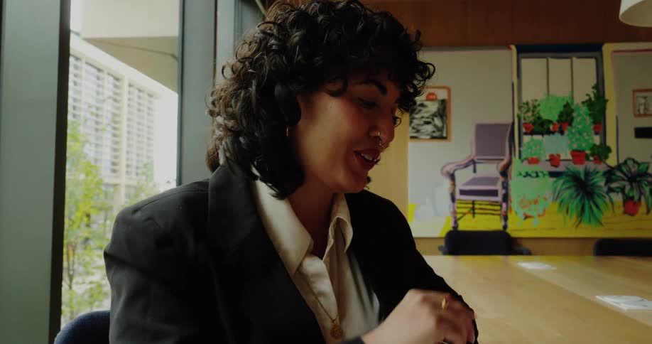 The face of a young woman who is using a laptop and talking while she is smiling
