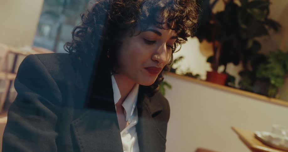 Close up portrait of a young woman sitting at a table in a lit restaurant