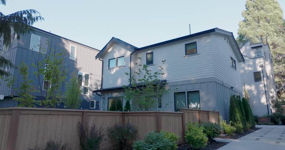 Pullback reveal of a modern two story home with for sale and open house real estate signs in the front yard