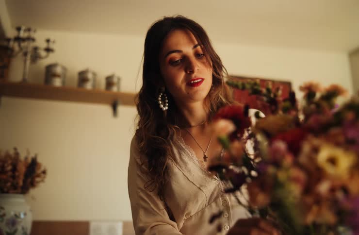 Mulher organizando flores em ambiente interno