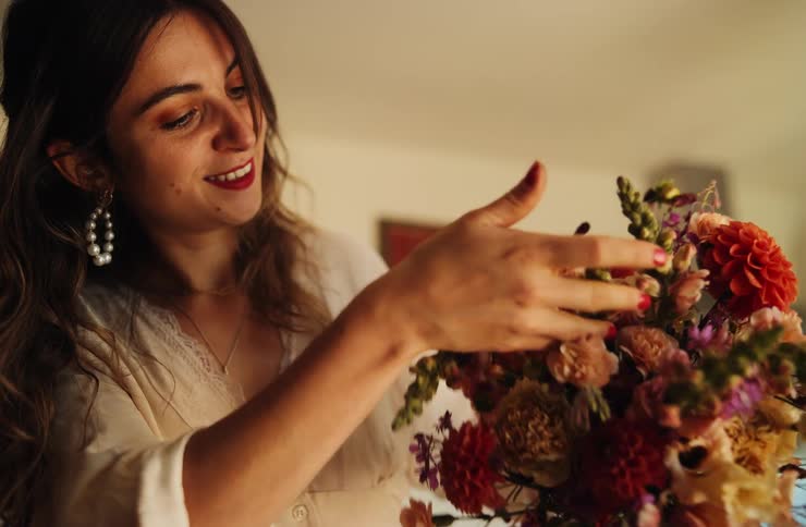 Woman holds colorful bouquet under warm lighting