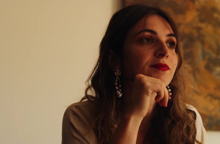 The woman is smiling and looking around