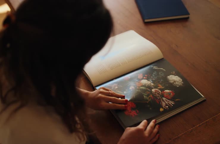 Woman flipping through a photography book while viewing a fullspread image
