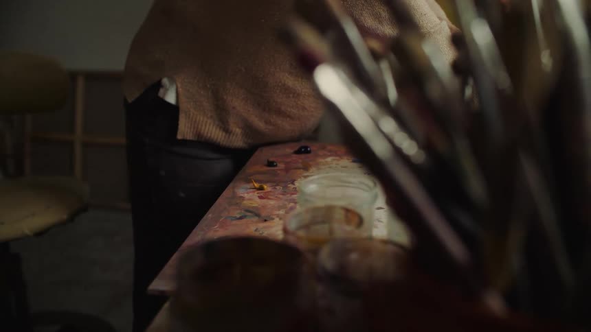 Paint mixing being prepared by a person on an art worktable