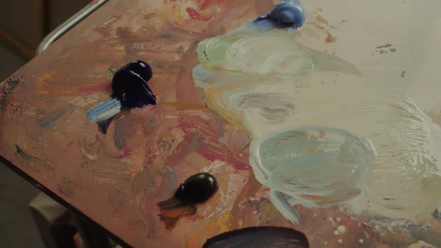 Closeup of a wooden artists palette with various oil paints