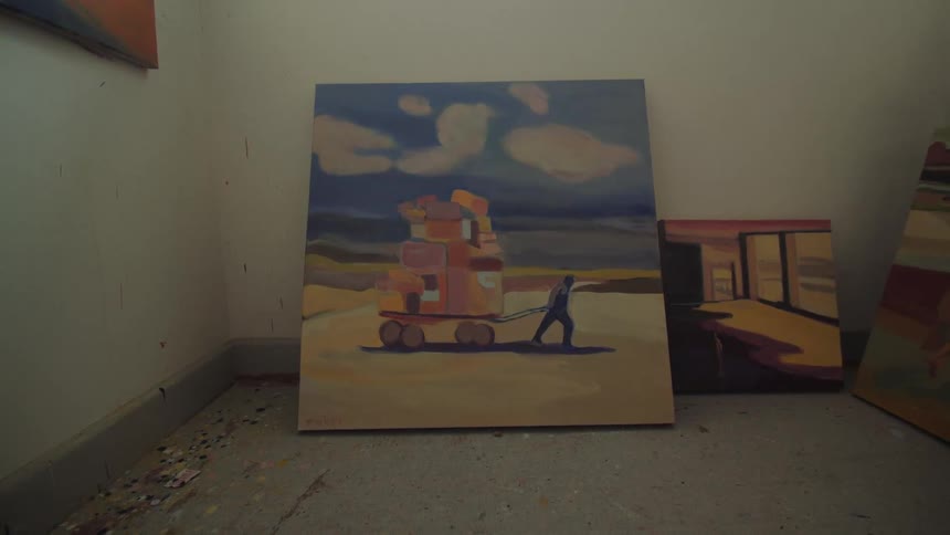 Small room with paintings on the ground and a painting on the wall indoors