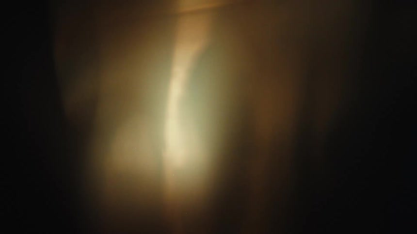 Diffuse light in golden and dark tones forms abstract pattern with illuminated center