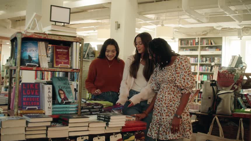 A group of female friends checking out books at a bookstore during daytime