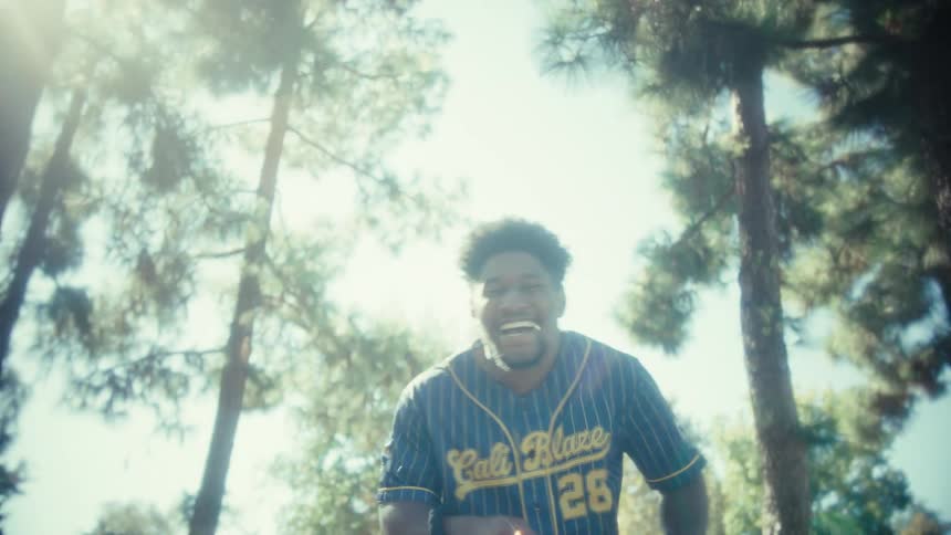 The man is laughing and running while holding a leash