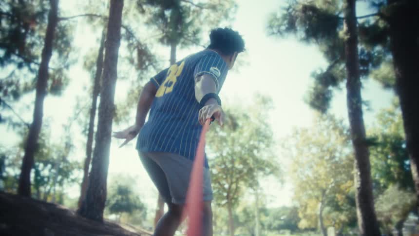 Man outdoors holding a stretched leash among trees