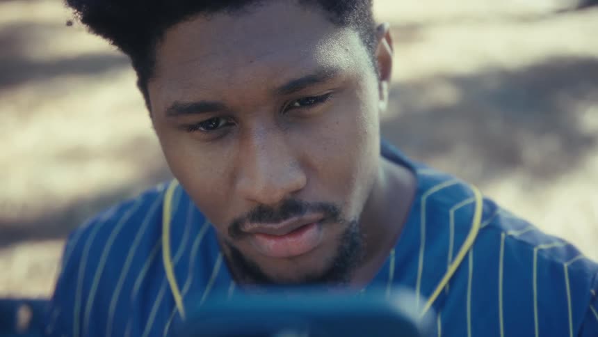 Young man looks at the phone in his hand with a curious look on his face