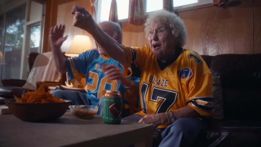 Couple of fans pointing at the tv while watching the game