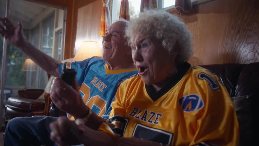 The man and woman are having fun watching a sports game