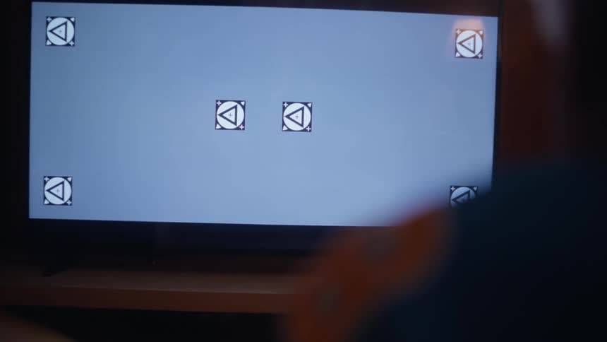 A man and woman cheer as they watch a television