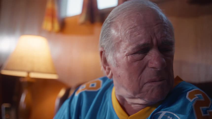 Man watching something with an anxious expression while wearing a sports jersey