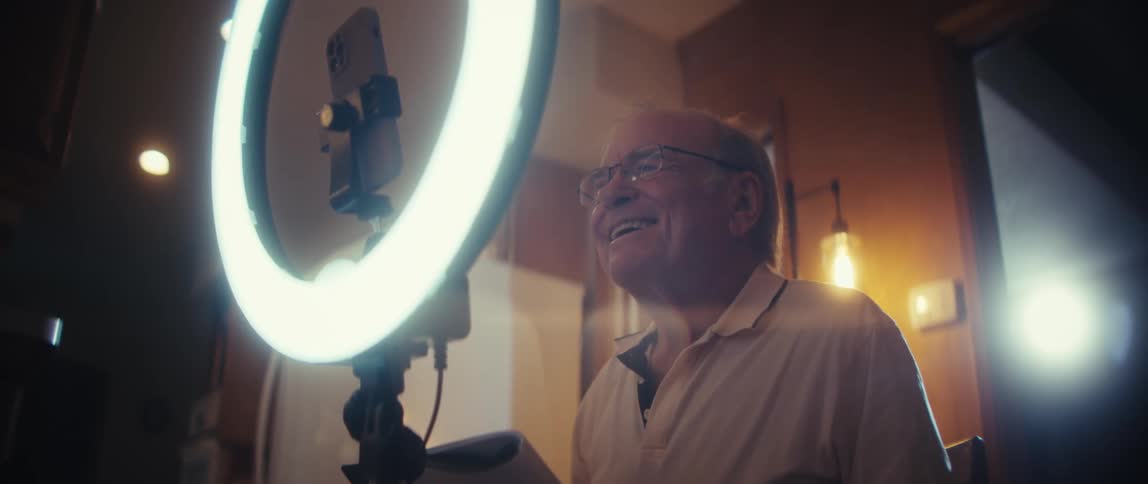 Elderly man in front of a ring light indoors