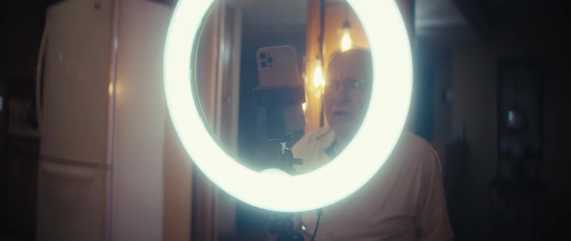 A man using a smartphone with a ring light