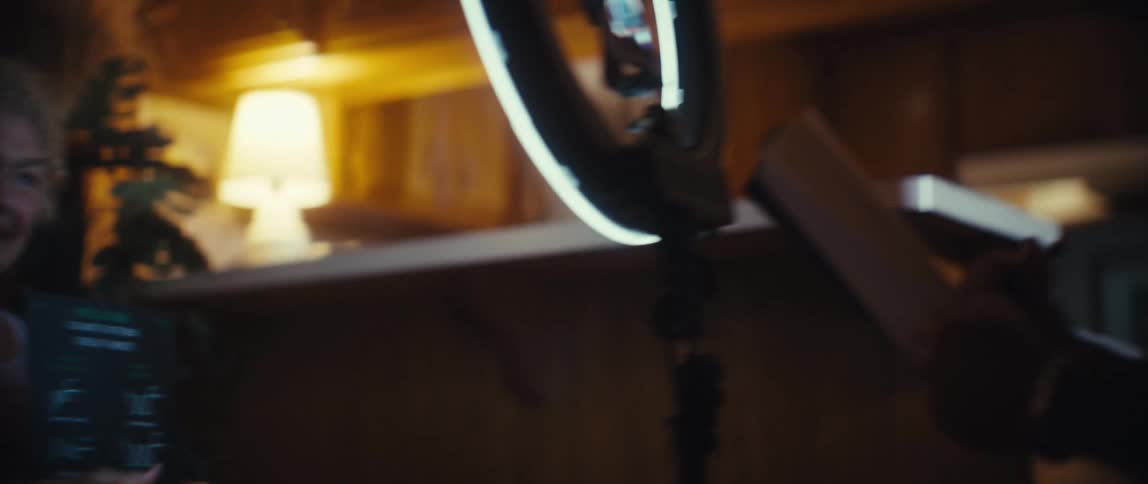 A cheerful older woman with curly hair is sitting in an armchair holding a bullish chart pattern cheat sheet and giving a enthusiastic thumbsup sign toward a ring lightcamera setup the scene then cuts to an older man with glasses smiling and givin