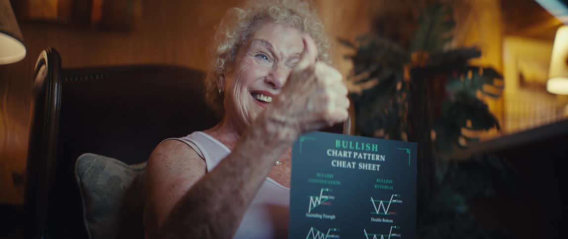 Elderly woman showing a bullish patterns guide and giving a thumbsup