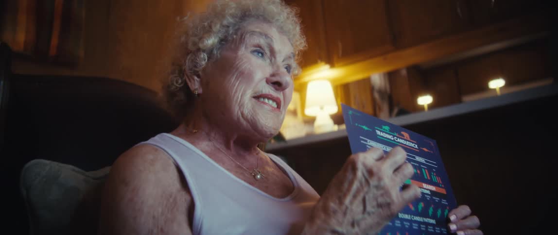 Elderly woman presenting a chart sheet while talking to a man in a ringlit setting