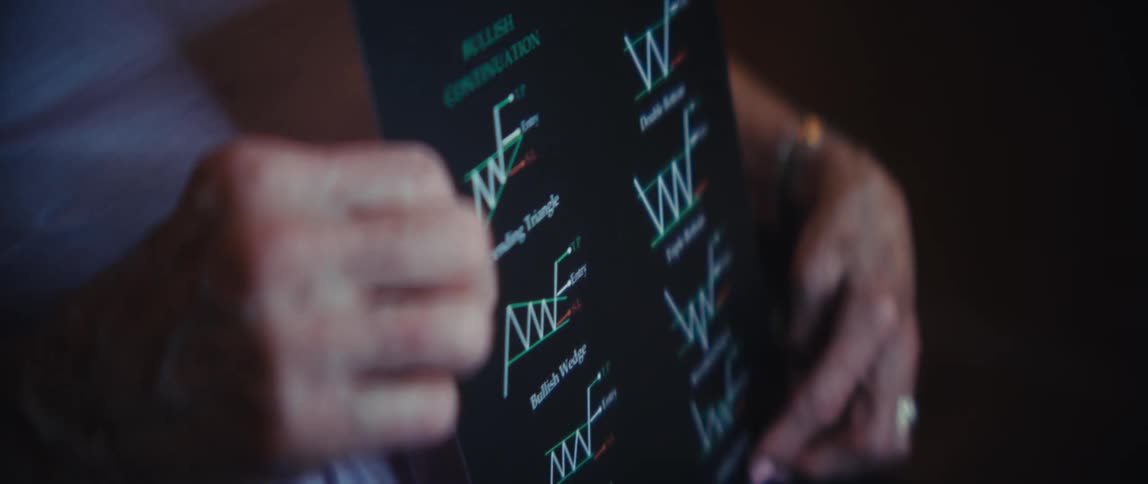 An elderly woman holds a pamphlet displaying stock market chart patterns