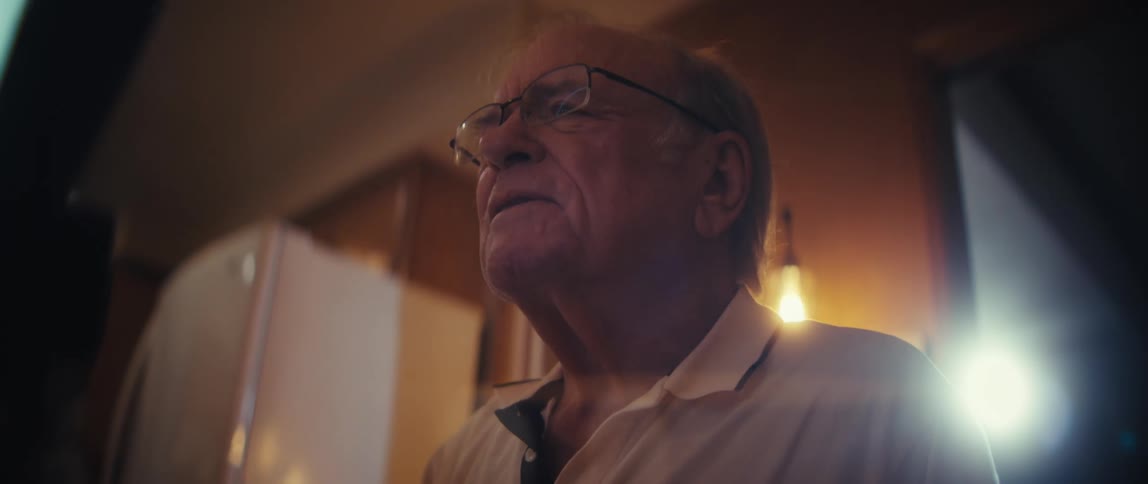 Elderly man in front of a ring light watching an elderly woman being recorded