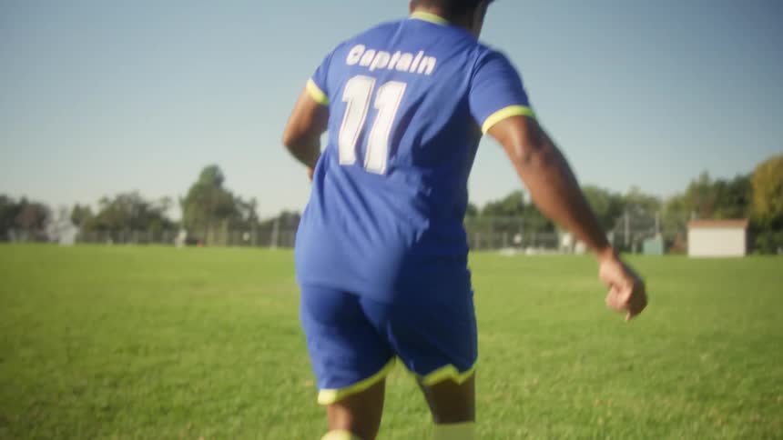 Player dribbling a ball between cones during training on a grass field