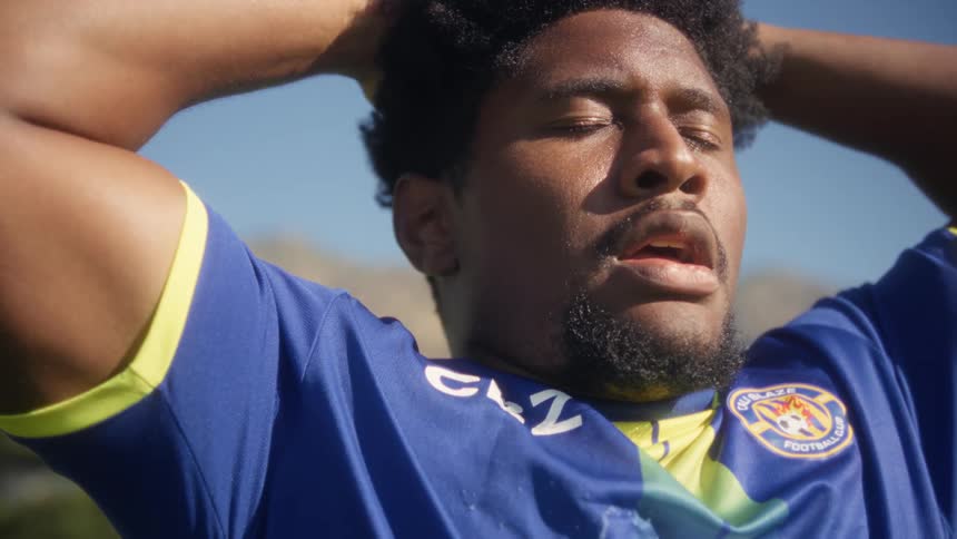 Close up portrait of a young black male soccer player outdoors at practice during daytime