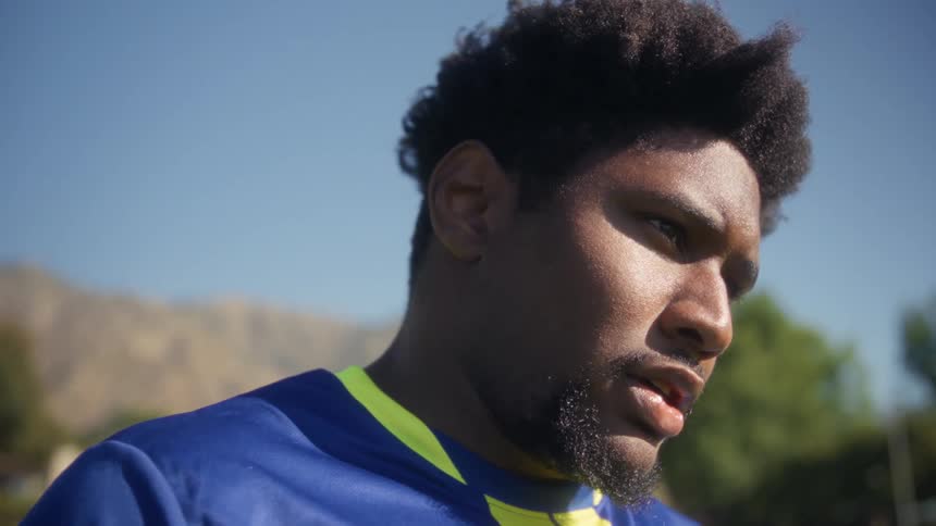Close up portrait of a young black soccer player at soccer practice outdoors during daytime