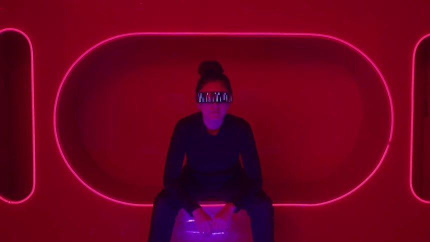 Person wearing a reflective visor sitting in a redlit environment
