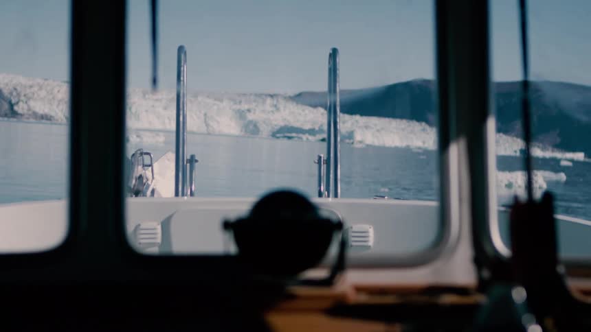 View from a boat sailing near a glacier as melting ice floats on arctic water