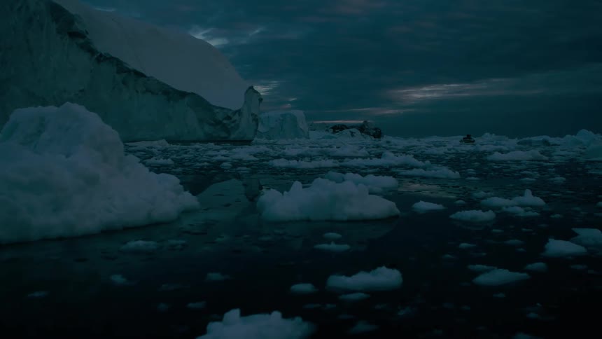 Chunks of ice broken off of a glacier are floating in the sea