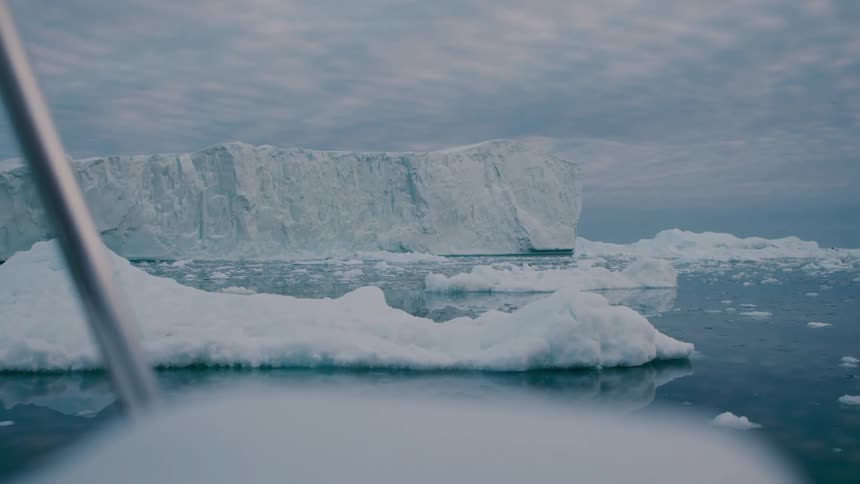 View from a boat of a glacier and melting ice floating on arctic water
