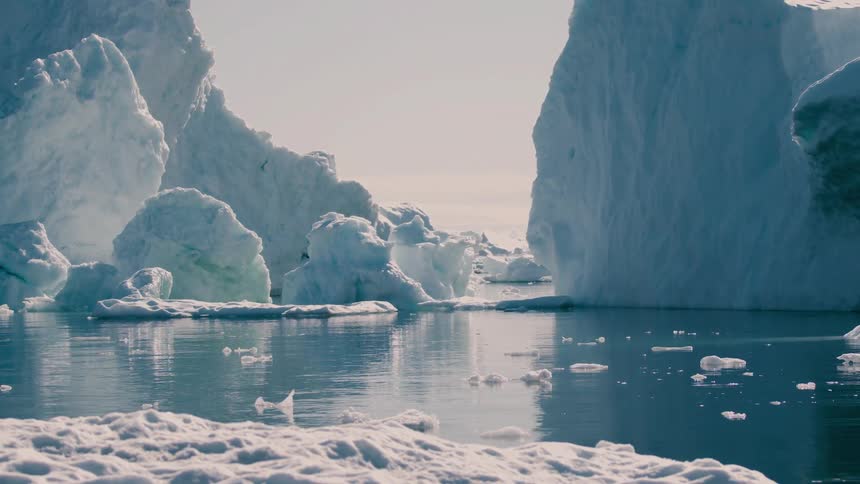 Melting ice floats by glaciers on arctic water