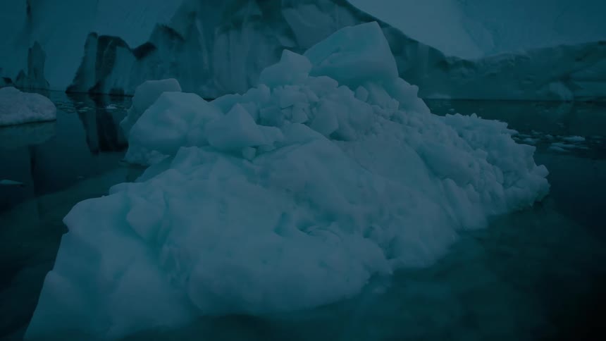 Arctic glacier with icebergs and melting ice floating on the water