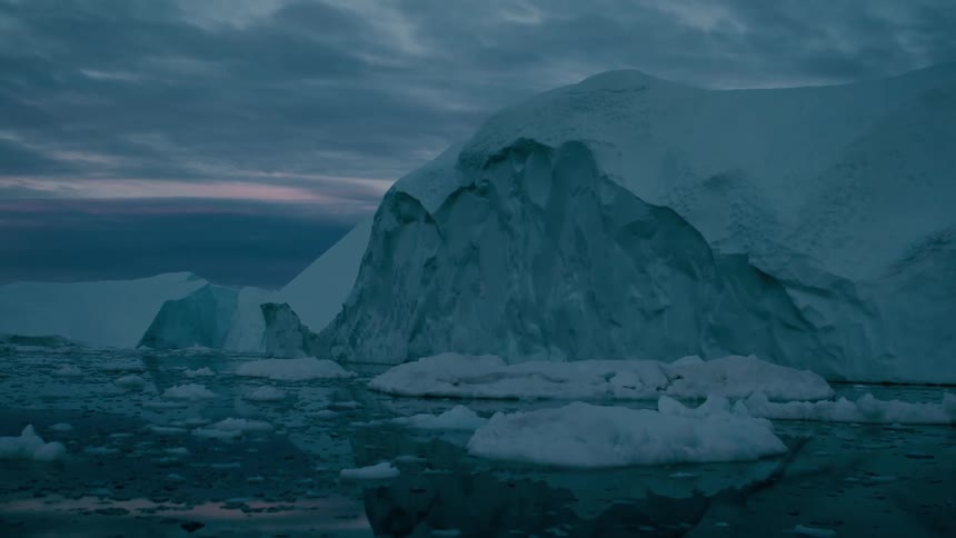 Glacier and melting ice floating on arctic water under a cloudy sky